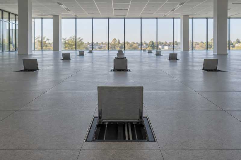 Plateau de bureaux vide, trappes de sol ouvertes sur le plancher technique