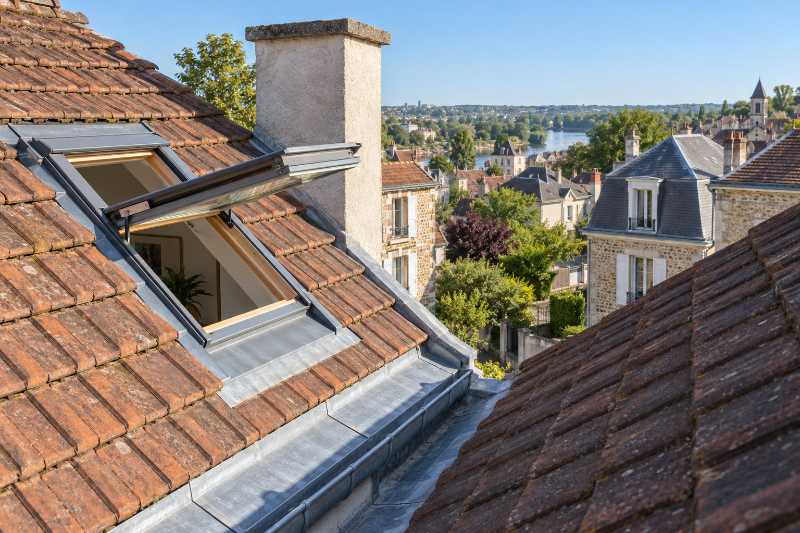 Fenêtre de toit ouverte dans un rampant en tuile plate