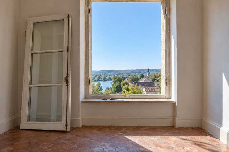 Vantail de fenêtre déposé et appuyé contre le mur intérieur, baie laissée entièrement nue